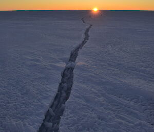 A tide crack in the sea ice seems to run all the way to the sun