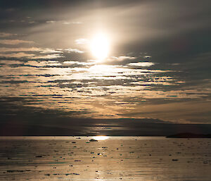 Looking over broken sea ice and the setting sun