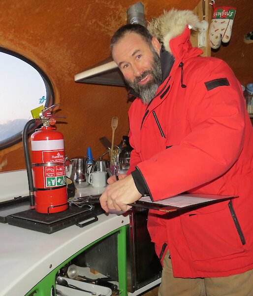 Even is seen weighing each extinguisher to ensure it has the correct amount of extinguishing agent.
