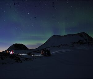 An aurora is seen over Colbeck hut and the Hägglunds.