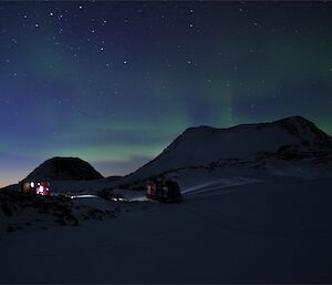 An aurora is seen over Colbeck hut and the Hägglunds.