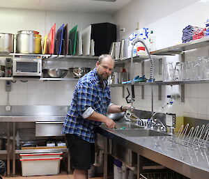 Paul in the kitchen cleaning pots.