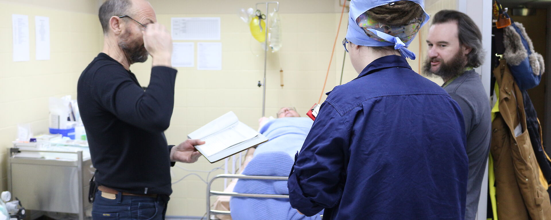 Expeditioners being briefed on patient care during training in the reception area.