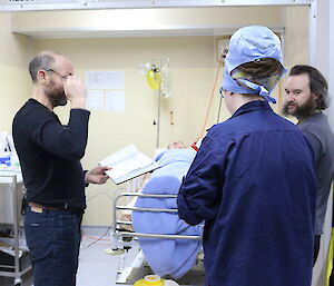 Expeditioners being briefed on patient care during training in the reception area.