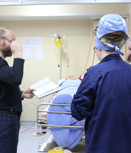 Expeditioners being briefed on patient care during training in the reception area.