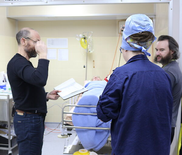 Expeditioners being briefed on patient care during training in the reception area.