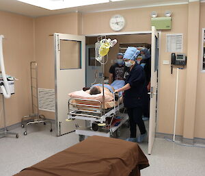 Expeditioners wheel the pretend patient into theatre for training.