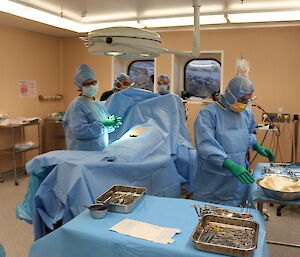 Expeditioners surround the pretend patient in theatre, ready to do a surgical training exercise.