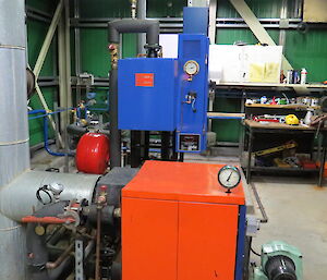 Inside the water supply building, the pumps and boilers are in this building, the diesel boiler is in the foreground and the blue electric boiler (powered by our wind turbines).