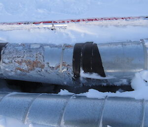 The offending section of pipe, the leak of warm water has melted out the snow and ice below.