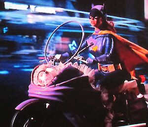 Batgirl on her scooter cruising the mean streets of Gotham City.