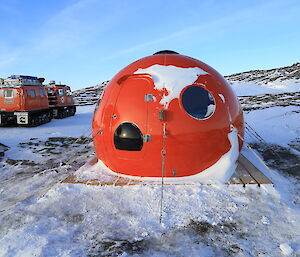 The new hut in situ already has snow on it and it’s asymmetrical windows resemble eyes.