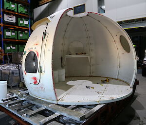 The old hut is shown, partially dismantled, in a workshop.