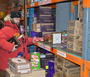 Male expeditioner jokingly liberating some chocolate in a storage warehouse