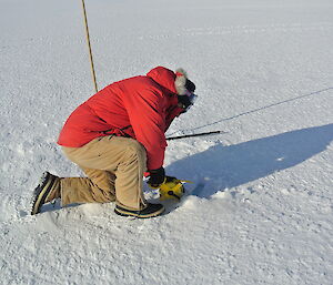 Kim measuring the depth of the sea ice.