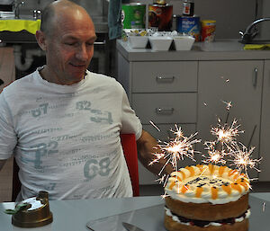 Charlie and his cake which is covered in sparkling sparklers.