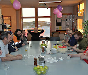 Linc cutting his cake with the station waiting to be served,