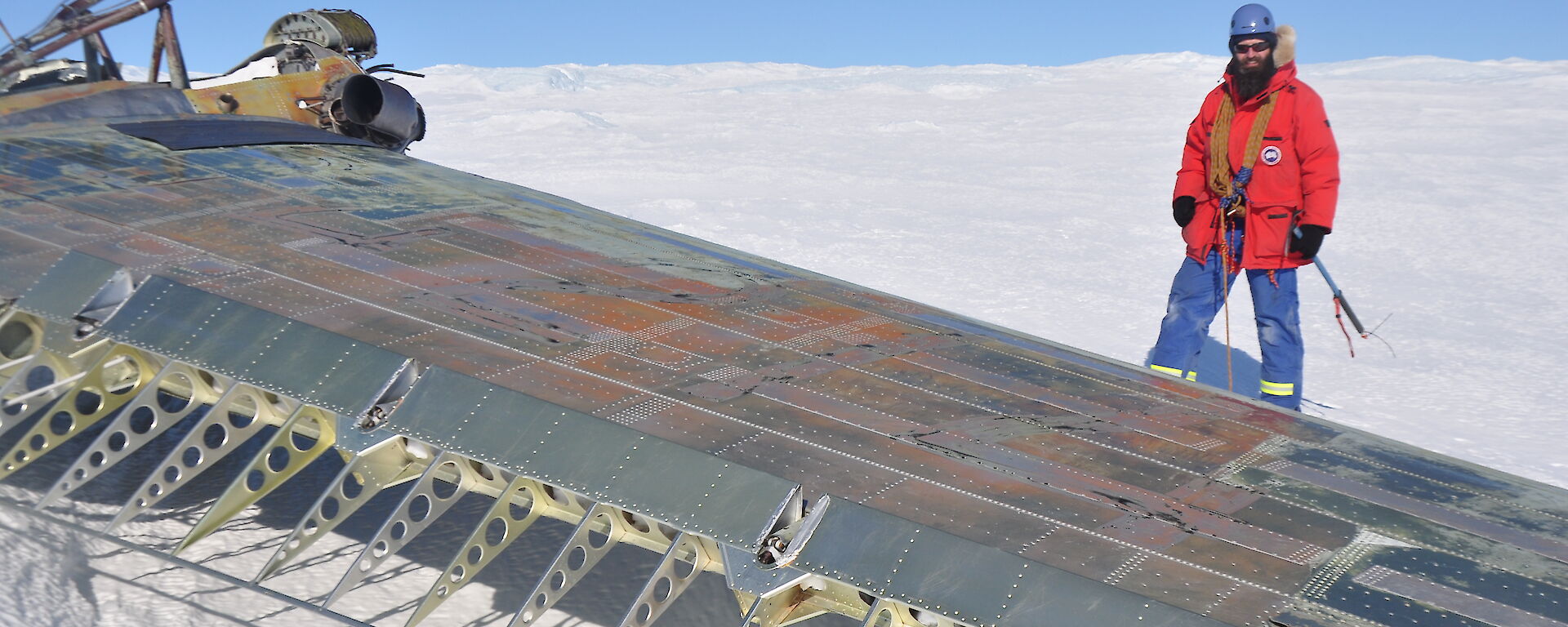 Trev standing by the wing of the aircraft of the aircraft which is upside down..