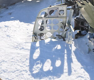 The instrument panel of the cockpit sticking up out of the snow. Blank holes where all the instruments and dials were located.