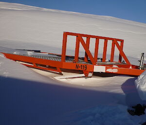 One of the sleds used to transport cargo around the plateau and sea ice half buried under snow drift.