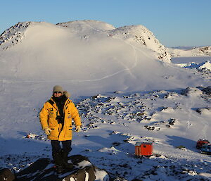 Angus Cummings above Colbeck hut with a Hägglunds beside the hut.