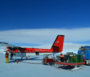 Small aircraft being refuelled with the plateau in the background.