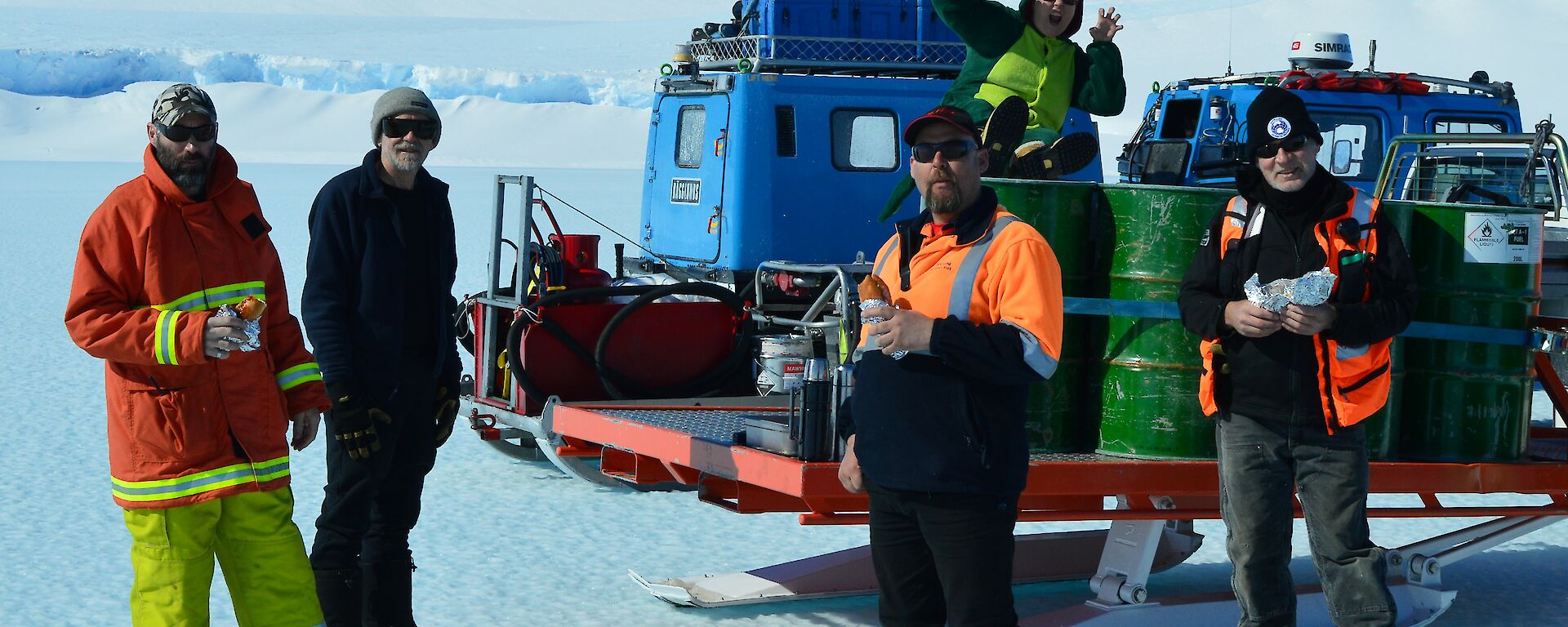 Smoko on the ice with ‘Angry’ while waiting for the aircraft to arrive. Not sure what Dorothy the Dinosaur is doing sitting on the fuel drums.