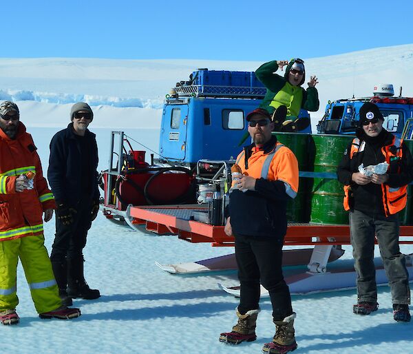 Smoko on the ice with ‘Angry’ while waiting for the aircraft to arrive. Not sure what Dorothy the Dinosaur is doing sitting on the fuel drums.