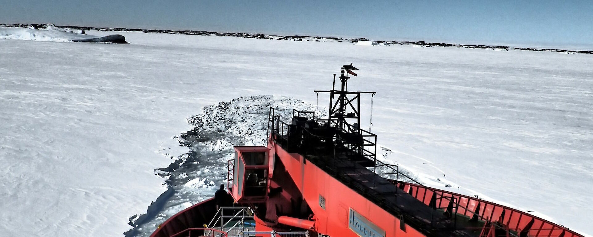 The Aurora Australis breaking through the ice and backing up before trying again — view is from the bow.