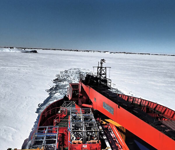 The Aurora Australis breaking through the ice and backing up before trying again — view is from the bow.