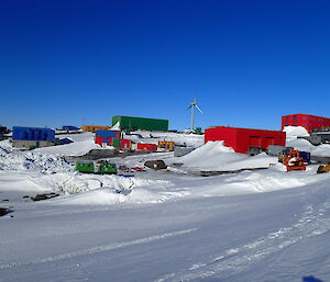 Picture of Mawson station from the ground, snow all around the bright buildings.