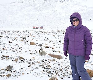 Kate enjoying the snow with the hut and the Hägglunds in the background.