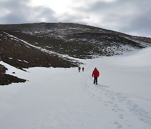 Three expeditioners walking back up out of the windscour.