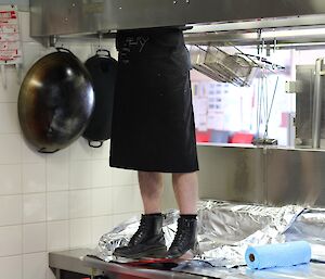 Linc with only the lower half of his body is showing off his best feature whilst scrubbing the exhaust hood.