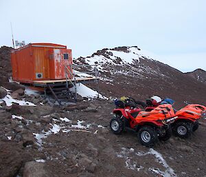 Mount Henderson hut with two quad bikes in front.