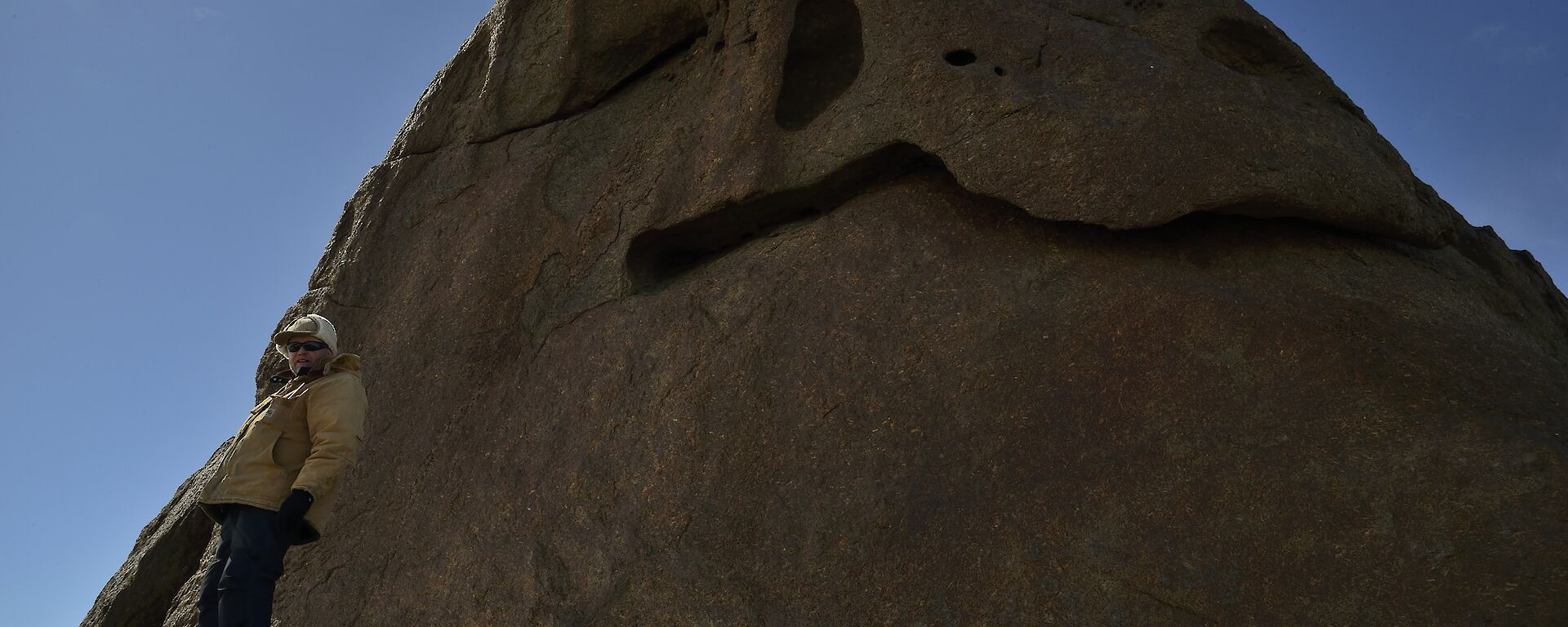 Mal next to a cliff face shaped like the head of the sleeping giant.