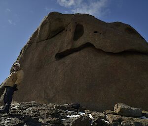 Mal next to a cliff face shaped like the head of the sleeping giant.