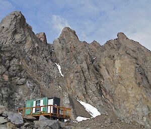 Rumdoodle hut in front of the rock wall.