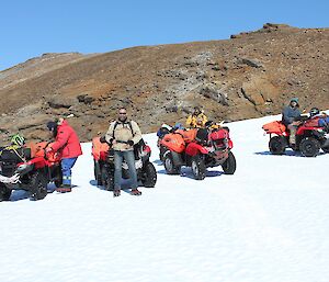 The quads arrive a Phillips Ridge — four men on quads in a row in various states of getting off