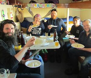 Seating around the table in the hut at Rumdoodle the cake is served.