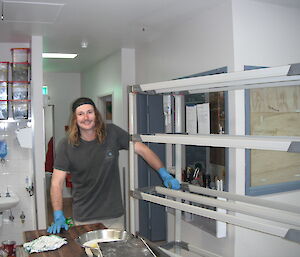 James scrubbing shelves in the kitchen