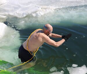 Older male expeditioner jumps into the icy water