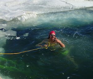 James in a bathing cap and goggles, emerges from a hole in the ice