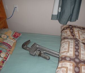 A large wrench in the bed under the doona