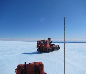 A large red truck on tracks driving across the Plateau