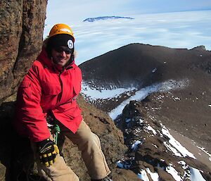 a man sitting on top of a Mountain with the Casey ranges in the background