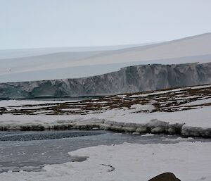 A glacier and water that is just starting to look icy