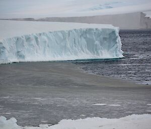 An iceberg with a channel in front of it that is half ice and half water
