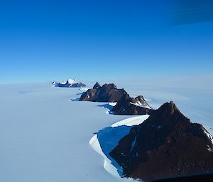 A row of Mountains surrounded by snow