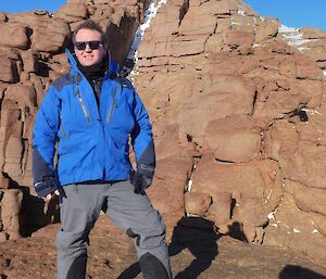 A man at the top of a mountain peak